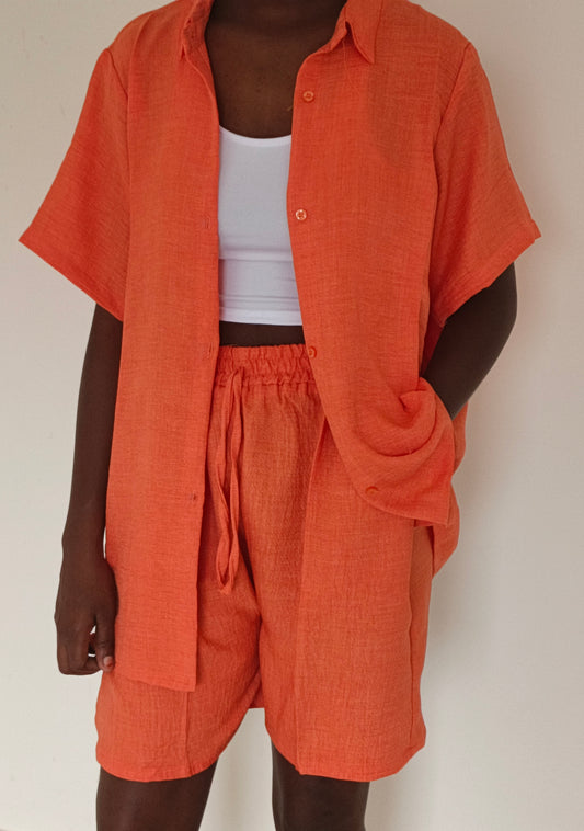 Fille debout portant l'ensemble 3 pièces orange, vue de face. 